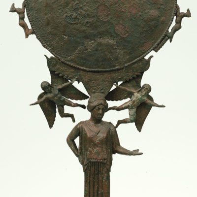 Bronze stand-mirror supported by the figure of peplos-clad maiden standing on a tripod base. Unknown provenance. Argive workshop. About 455 BC (X 7579).